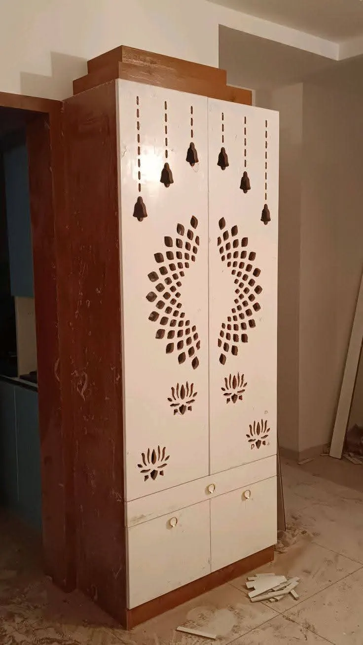 Teak-finish pooja cabinet with a mandala jali door during installation at the site