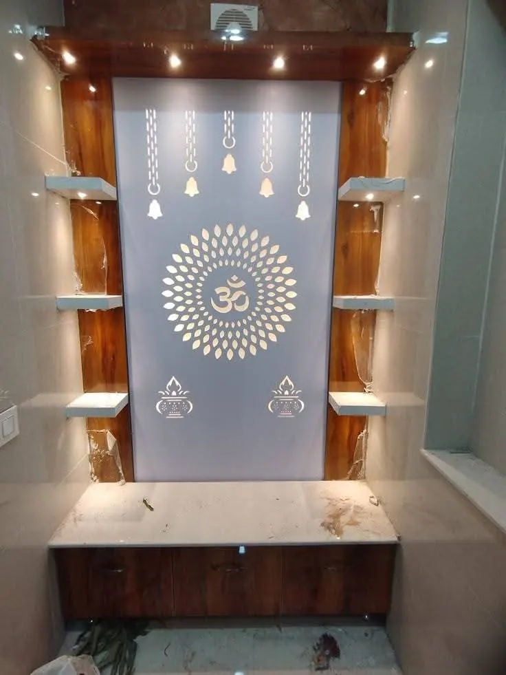 Backlit pooja niche with an Om mandala panel and floating glass shelves
